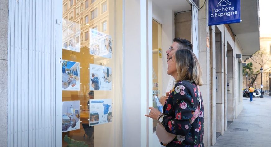 Una mujer mira los anuncios en el escaparate de una inmobiliaria