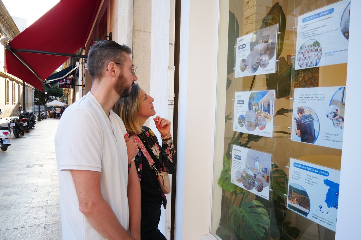 Una pareja ante el escaparate de una inmobiliaria en España
